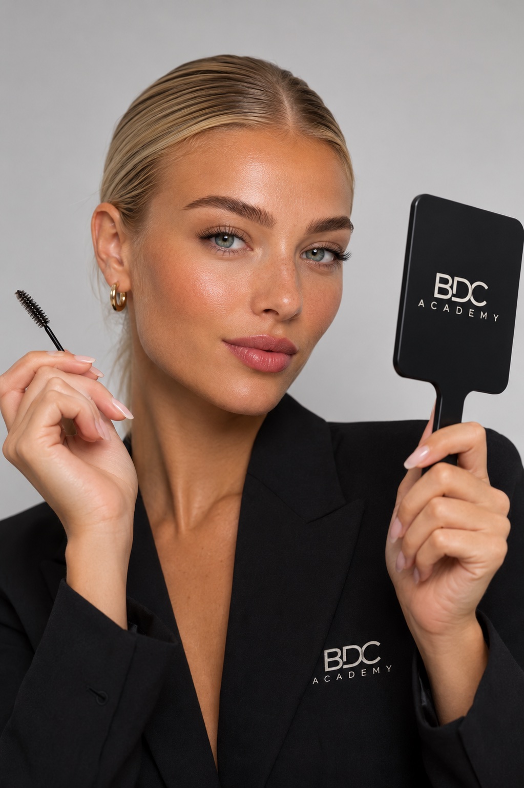 Technicienne Beauté du Cil Academy tenant un miroir au logo BDC